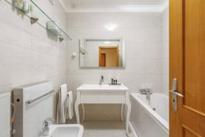 un bagno bianco con lavandino e vasca di Maison Soleil Oeiras a Oeiras Altre 34 foto