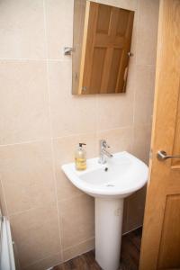 a bathroom with a sink and a mirror at Happy staying in Wythenshawe