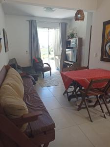 a living room with a couch and a table at Praia de Palmas in Governador Celso Ramos