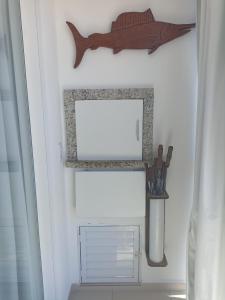 a shelf with a picture of a fish on a wall at Praia de Palmas in Governador Celso Ramos