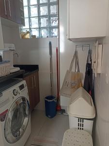 a kitchen with a washing machine and a window at Praia de Palmas in Governador Celso Ramos