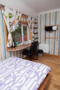Schlafzimmer mit einem Schreibtisch, einem Bett und einem Stuhl in der Unterkunft Happy staying in Wythenshawe