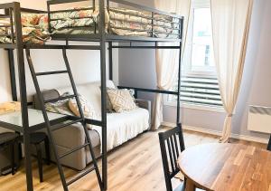 a room with two bunk beds and a table at Studio Montévrain RER in Montévrain