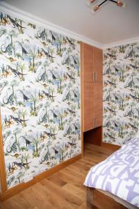 un dormitorio con una pared con un mural de animales en Happy staying, en Wythenshawe