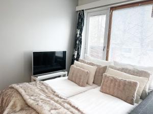 a living room with a white couch and a tv at Cozy city suites in Rovaniemi
