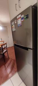 um frigorífico de aço inoxidável num quarto com uma mesa em Departamento chillan em Chillán