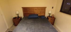 ein Schlafzimmer mit einem Bett mit zwei Nachttischen und zwei Lampen in der Unterkunft Departamento chillan in Chillán
