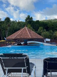 a swimming pool with a gazebo and two chairs at Karibbean Resort in Sainte-Luce