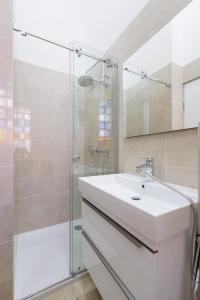 a bathroom with a white sink and a shower at Cozy & 3 minutes from main square - J in Zagreb