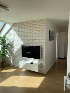 a living room with a tv on a brick wall at Appartement 3p Ivry in Ivry-sur-Seine