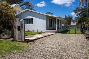 a white house with a fence and a gravel driveway at Eurie Eurie on Beachview in Berrara