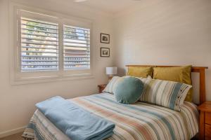 a bedroom with a bed and a window at Eurie Eurie on Beachview in Berrara