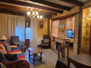 sala de estar con sofá y chimenea en Casa Rural La Vid, en Cadalso de los Vidrios