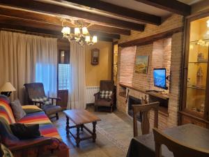 a living room with a couch and a fireplace at Casa Rural La Vid in Cadalso de los Vidrios