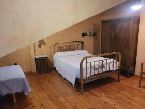 um quarto com uma cama de metal num sótão em Casa Rural La Vid em Cadalso de los Vidrios