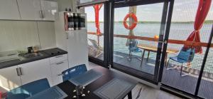 een keuken met een tafel en stoelen en uitzicht op het water bij Ma maison sur L'eau - Lac du Der in Giffaumont