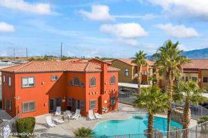 ein Apartmentgebäude mit einem Pool und Palmen in der Unterkunft Mesquite Retreat 2 Bd Condo by Cool Properties LLC in Mesquite