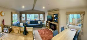 a living room with a couch and a tv at Appleblossom Lodge, Lido Leisure Park, Knaresborough in Knaresborough