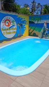 a large swimming pool at a resort with a sign at Peroba Mar Kitnets in Maragogi