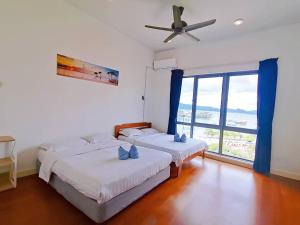 um quarto com 2 camas e uma ventoinha de tecto em Seaview Sunrise Suite Imago Loft D 3 bedrooms 1600 sqft above Imago Shopping Mall em Kota Kinabalu