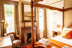 a bedroom with a four poster bed and a fireplace at Rhumhor House in Carrick