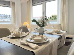 a dining room table with plates and glasses on it at Exclusivo Apartamento Con Parking in Torrelavega