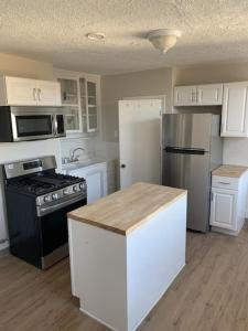 a kitchen with white cabinets and a black and white appliances at Cozy Cambridge Apt in Cambridge
