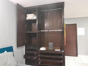 a bedroom with a dresser and a cupboard at Flat Palladium in São Vicente