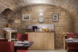 a dining room with a stone wall at Hôtel Le Compostelle in Paris