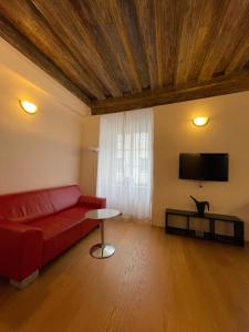 a living room with a red couch and a flat screen tv at Cozy Dachsberg in Krems an der Donau