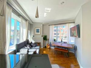 a living room with a couch and a table and windows at Gorgeous Three Bedroom West Village Townhouse in New York