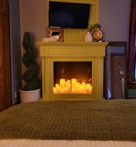 a yellow fireplace with a television on top of it at Inn 31 in Kingsville