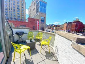 a group of yellow chairs and a grill on a rooftop at Gorgeous Three Bedroom West Village Townhouse in New York