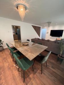 uma sala de jantar com uma mesa e cadeiras verdes em Modern 4 bedroom entire house 8 Sleep em Basildon