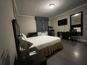 a hotel room with a bed and a desk at Travelodge by Wyndham London Ontario in London
