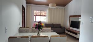 ein Wohnzimmer mit einem Tisch und einer Blumenvase darauf in der Unterkunft Pousada Bela Vista do Capão in Vale do Capao