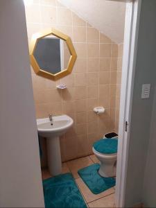 W łazience znajduje się umywalka, toaleta i lustro. w obiekcie Gentle Breeze w mieście Burgersfort