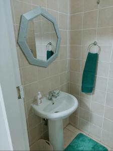 W łazience znajduje się umywalka i lustro. w obiekcie Gentle Breeze w mieście Burgersfort