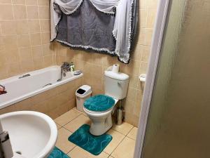 W łazience znajduje się toaleta, wanna i umywalka. w obiekcie Gentle Breeze w mieście Burgersfort