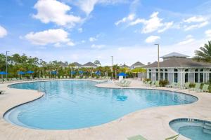a pool at a resort with chairs and umbrellas at Paradise Key at Lost Key Golf & Beach Club in Pensacola