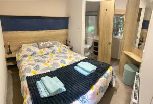 a bedroom with a bed with two towels on it at Appleblossom Lodge, Lido Leisure Park, Knaresborough in Knaresborough
