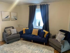 a living room with two blue couches and a window at Cozy Cambridge Apt in Cambridge
