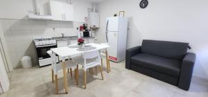 uma pequena cozinha com uma mesa e um sofá preto em Maras Rental #4 em Rio Grande