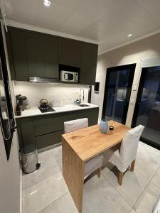 a kitchen with a wooden table and white chairs at Cabaña KILI Cabra Corral in Coronel Moldes