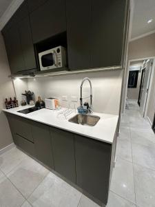 a kitchen with a sink and a microwave at Cabaña KILI Cabra Corral in Coronel Moldes