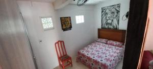 1 dormitorio con 1 cama y 1 silla en Casa do Bill Recreio, en Río de Janeiro