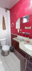 Baño rojo con aseo y lavamanos en Casa do Bill Recreio, en Río de Janeiro