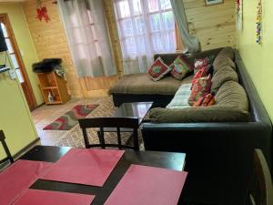 sala de estar con sofá y mesa en Casa Cabaña Oro Rayado Puerto Varas en Puerto Varas