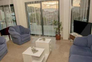 a living room with two chairs and a tv at Sun Hotel in Çeşme