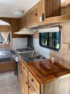 a kitchen with a sink and a stove in an rv at Private Caravan and facilities - Tarzali Valley Veiws in Tarzali